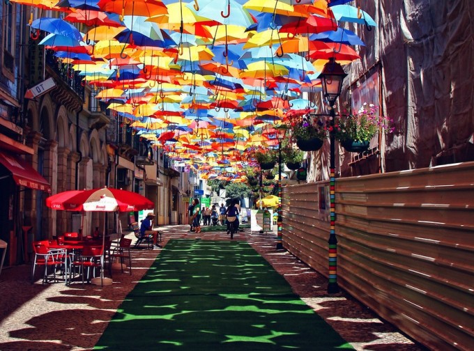 Calle cubierta por paraguas de multiples colores en Portugal